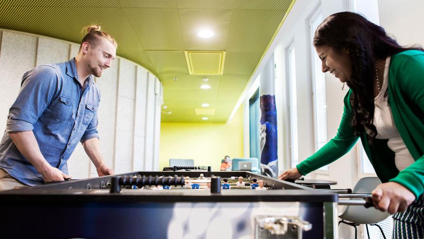 Two students playing table football on a break.