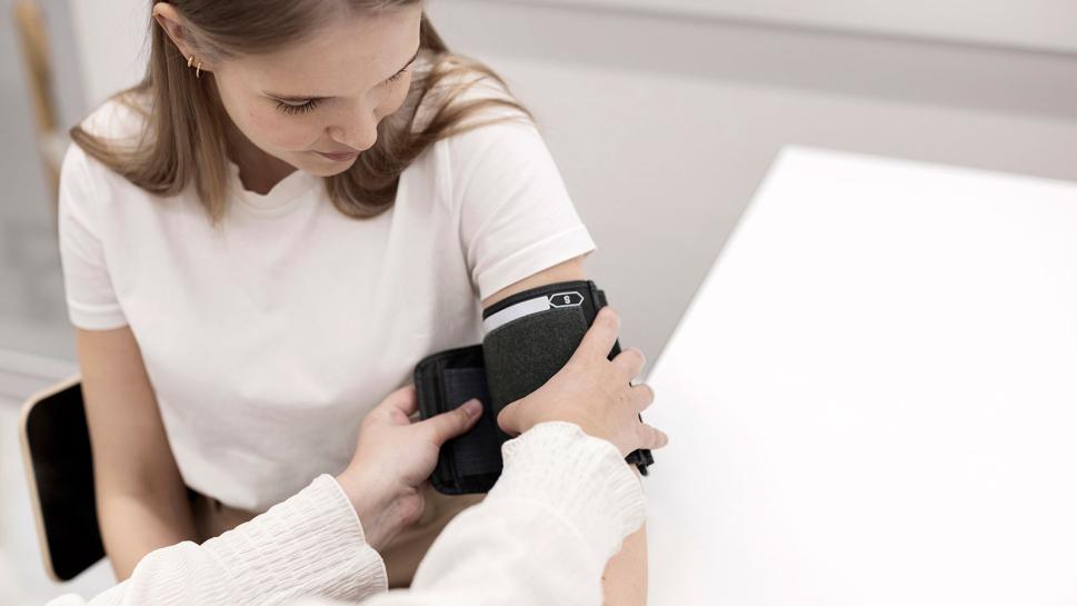 A student nurse measures a client's blood pressure.
