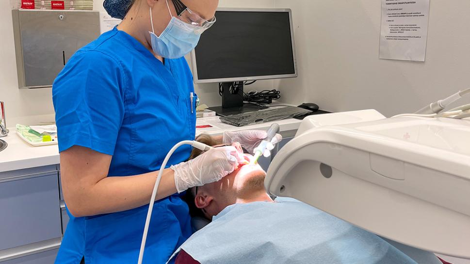 Suuhygienistiopiskelija suorittaa hammaskivenpoistoa